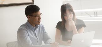 2 people working on laptop